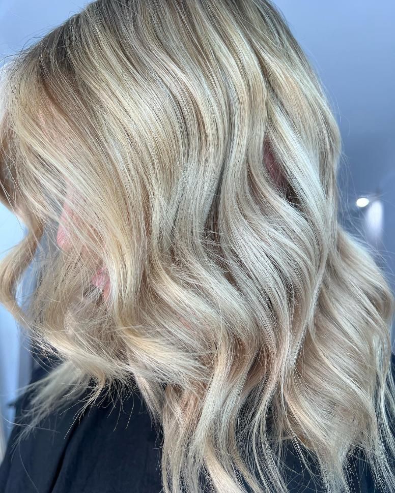 A Woman with Blonde Hair Is Wearing a Black Shirt — Losh Hair Lounge In Toowoomba City, QLD