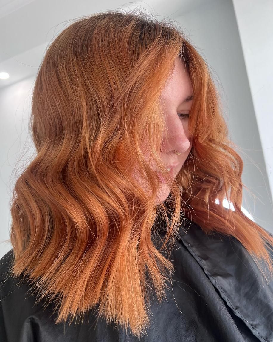 A Woman with Red Hair Is Wearing a Black Cape — Losh Hair Lounge In Toowoomba City, QLD