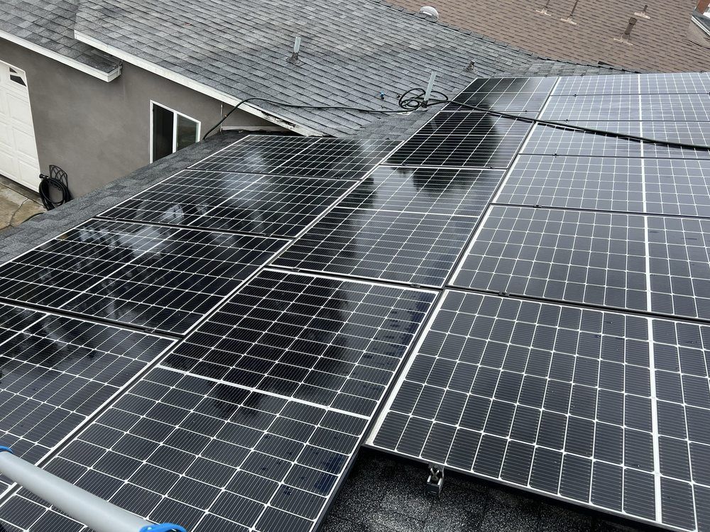 A high-angle view of solar panels installed on a residential shingle roof.