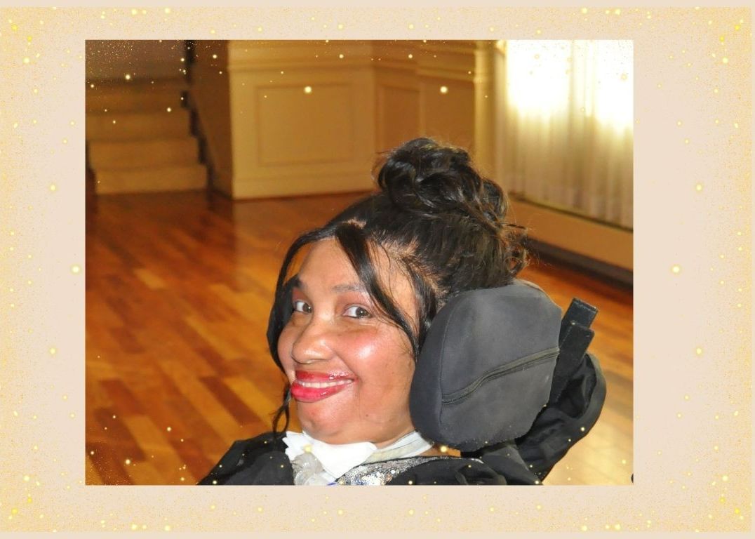 A woman in a wheelchair is smiling for the camera