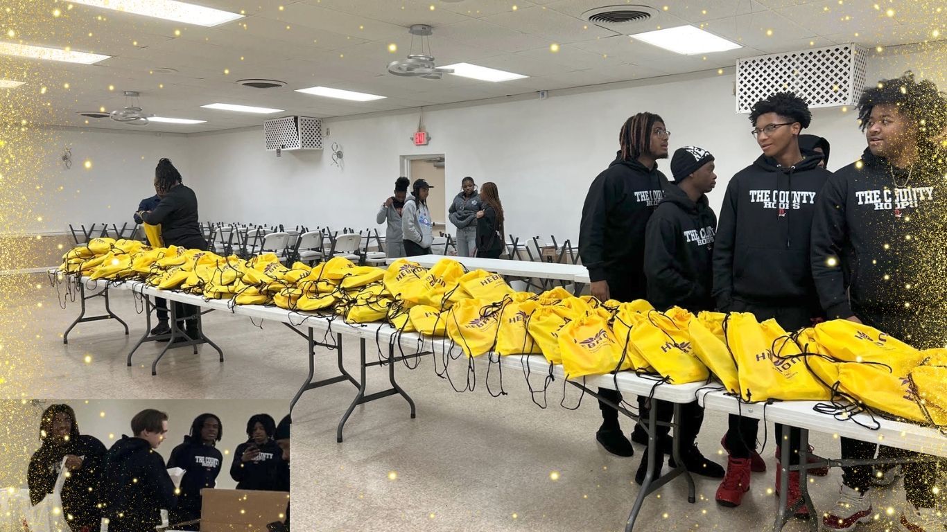 A group of people are standing around tables filled with yellow bags.