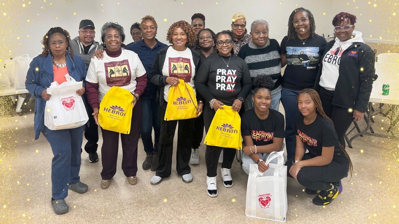 A group of people are posing for a picture while holding bags.