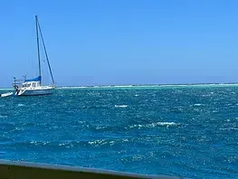 A sailboat is floating on top of a large body of water.