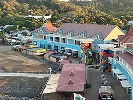 An aerial view of a colorful building with a red roof