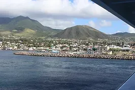 A view of a city from a boat with mountains in the background.