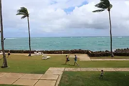 A group of people are walking on a beach near the ocean.