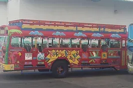 A red double decker bus is parked in front of a building.