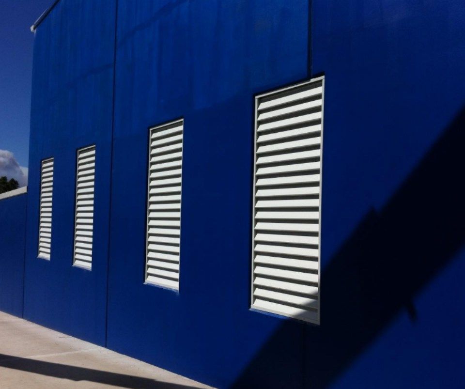 A blue building with white shutters on the windows