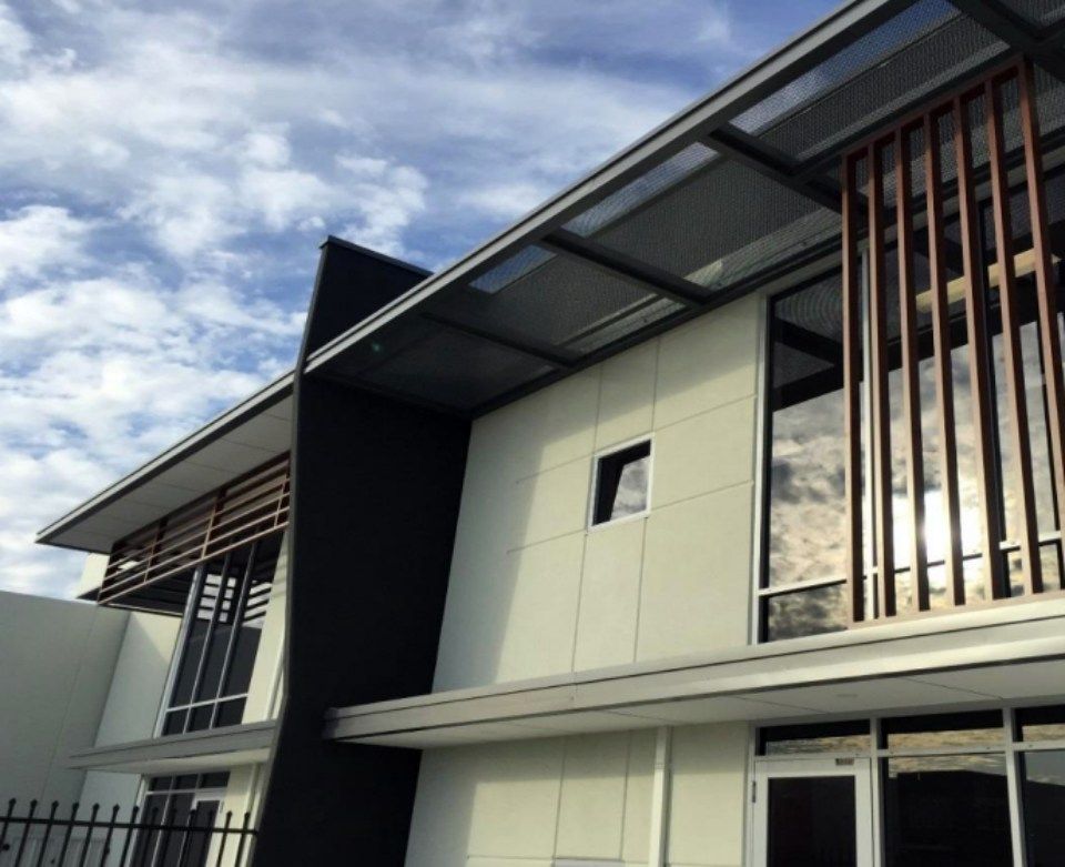 A building with a fence around it and a blue sky in the background