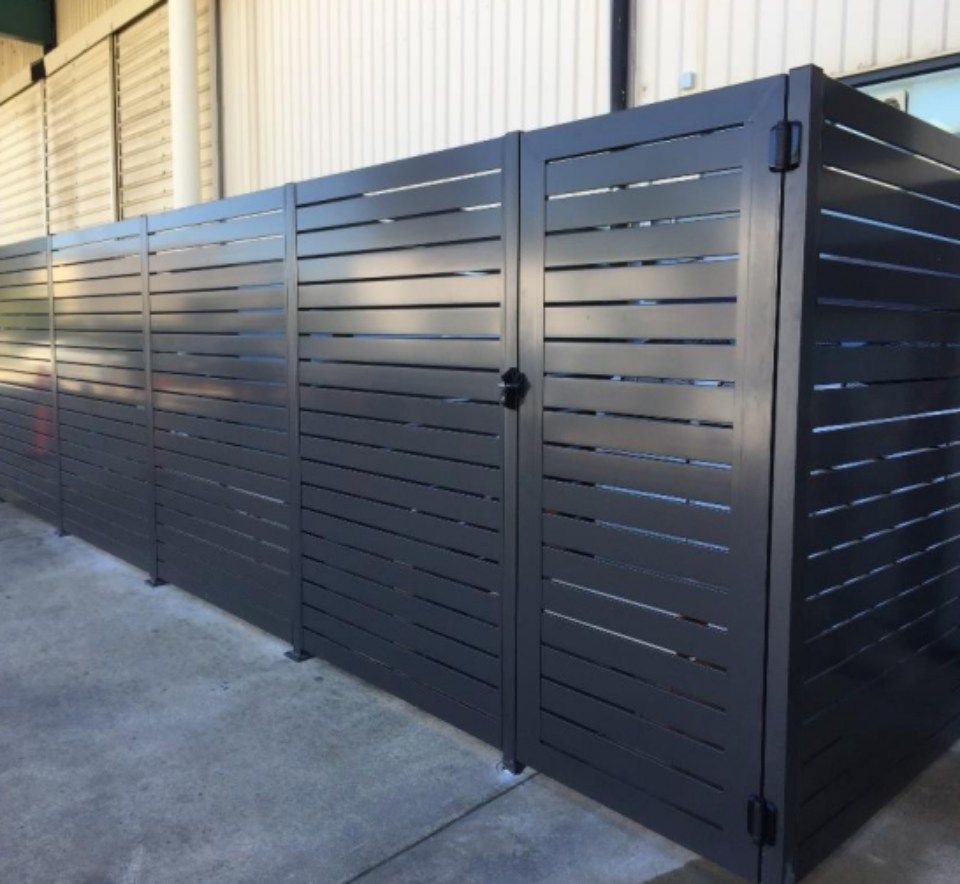 A black fence with a gate in front of a building