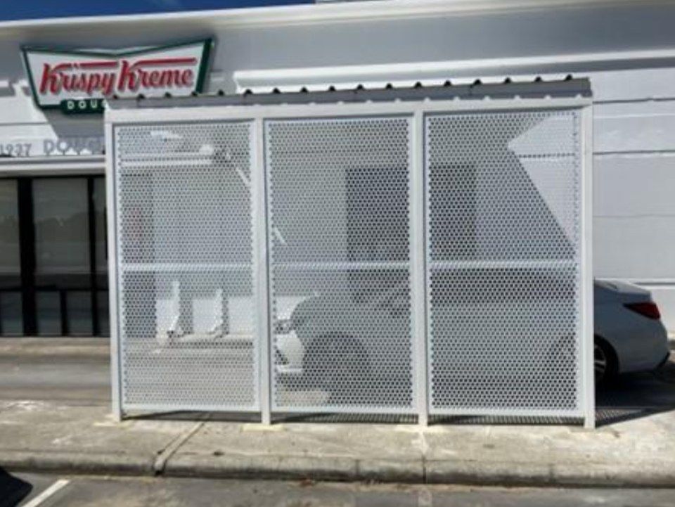 A white car is parked in front of a krispy kreme store