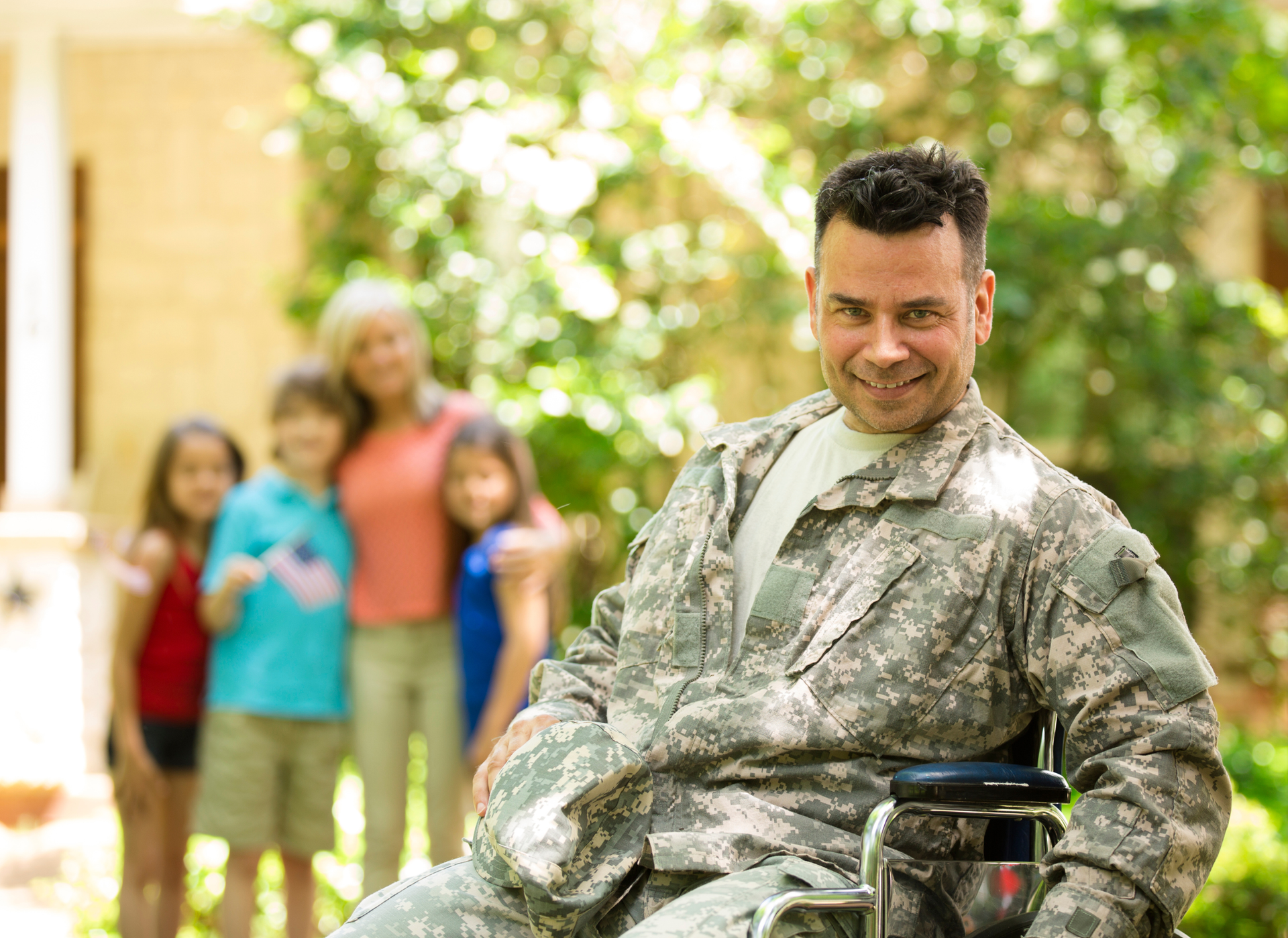A man wearing a vietnam veteran hat is standing in front of an american flag.