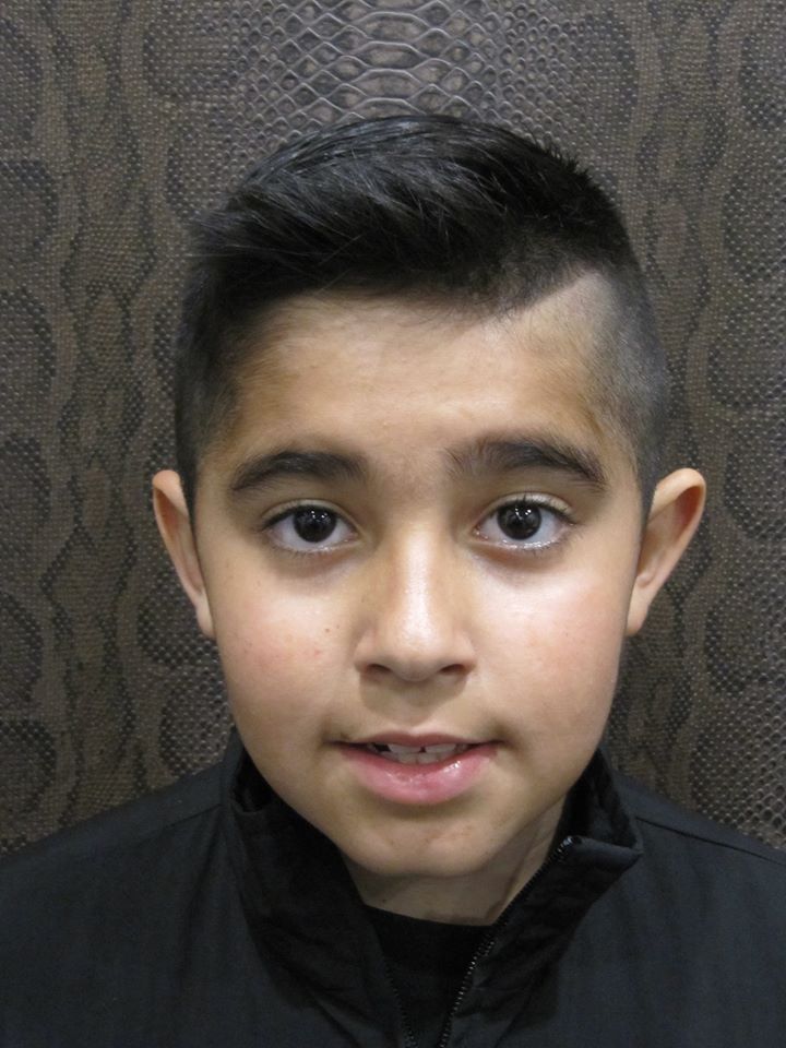 Un niño que lleva una chaqueta negra mira a la cámara.