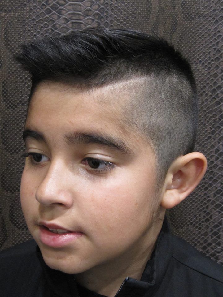 Un niño pequeño con la cabeza rapada lleva una camisa negra.