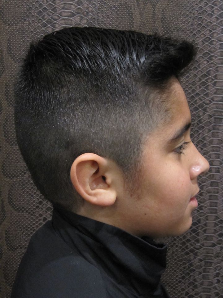 Un niño pequeño con pelo corto lleva un jersey de cuello alto negro.