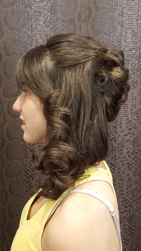 La mujer lleva una camiseta amarilla y tiene el pelo recogido en un moño.