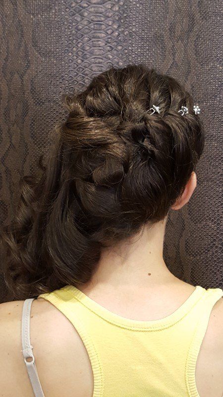 La espalda de una mujer que lleva una camiseta amarilla sin mangas y una cola de caballo trenzada.