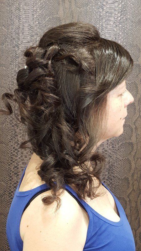 Una mujer con una camiseta azul lleva el pelo recogido mitad arriba y mitad suelto.