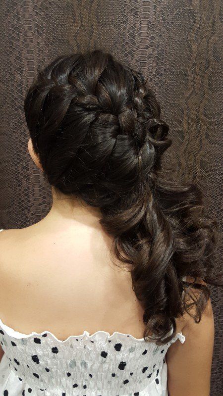 La espalda de una mujer que lleva una cola de caballo trenzada.