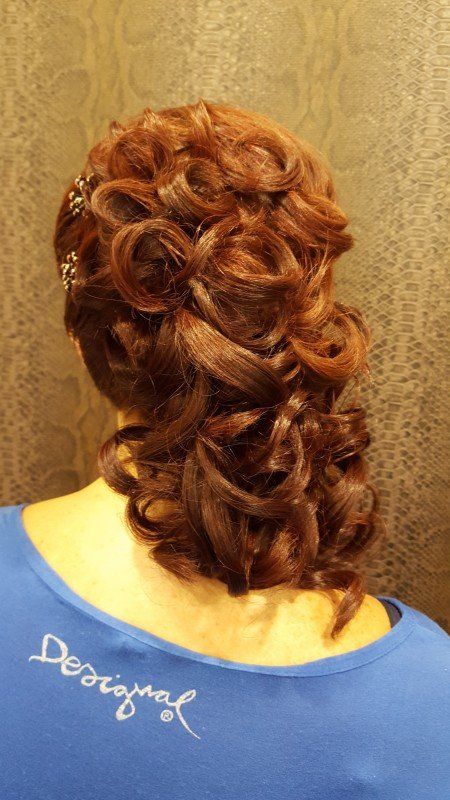 Una mujer lleva una camisa azul con la palabra desigual bordada en la espalda.