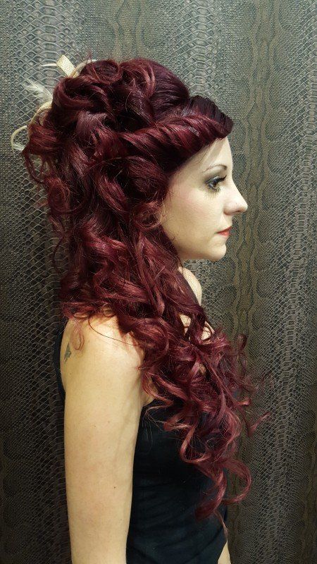 Una mujer con cabello largo y rojo lleva una blusa negra.