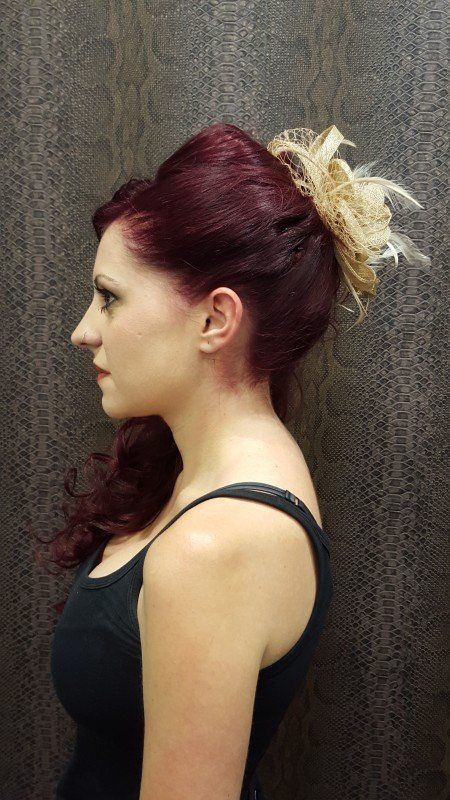 Una mujer pelirroja lleva una camiseta negra sin mangas.