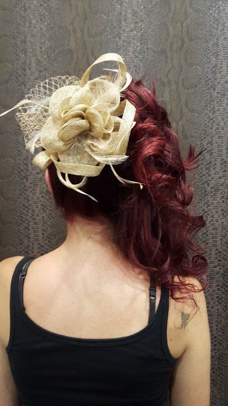 La espalda de una mujer que lleva un sombrero con una flor en el pelo.