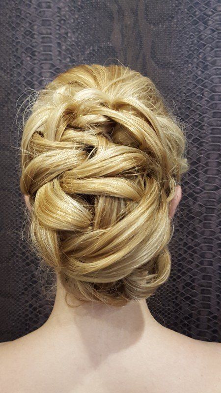 La espalda de una mujer con cabello rubio recogido en un moño.