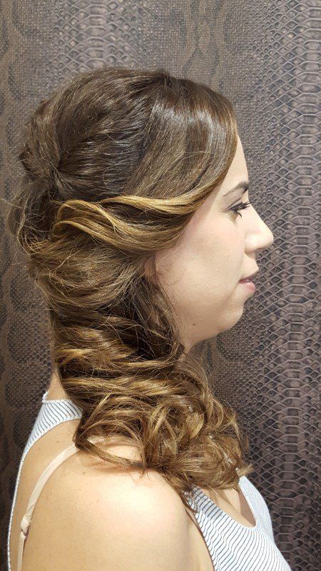 Una mujer con cabello largo lleva un peinado mitad recogido mitad suelto.