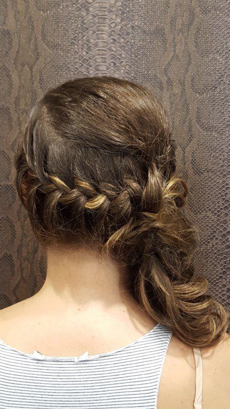 La espalda de una mujer que lleva una cola de caballo trenzada.