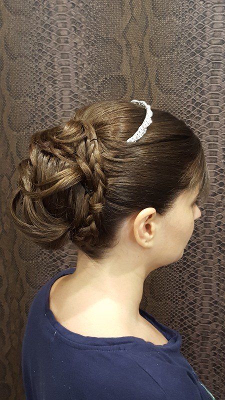 Una mujer lleva un moño trenzado con una diadema.