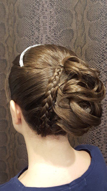 Una mujer lleva un moño trenzado con una diadema.