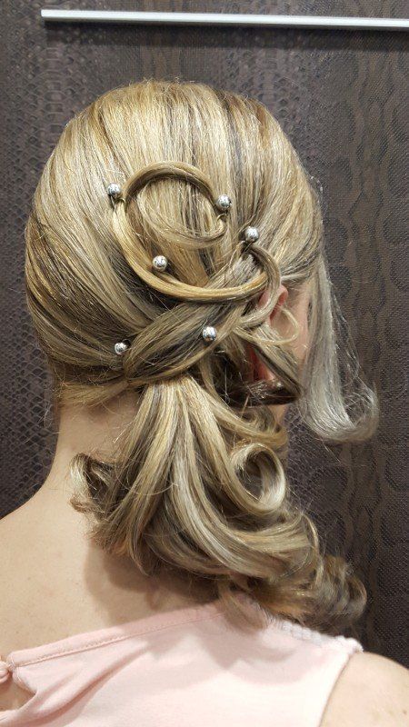 La parte posterior de la cabeza de una mujer con una cola de caballo y perlas en el cabello.