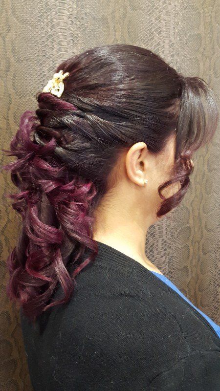 Una mujer con cabello morado lleva una cola de caballo.