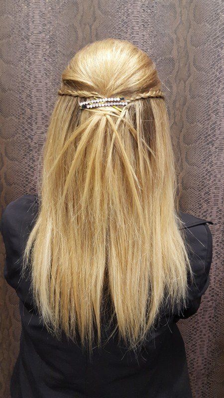 Una mujer con cabello largo y rubio lleva un peinado mitad recogido y mitad suelto.