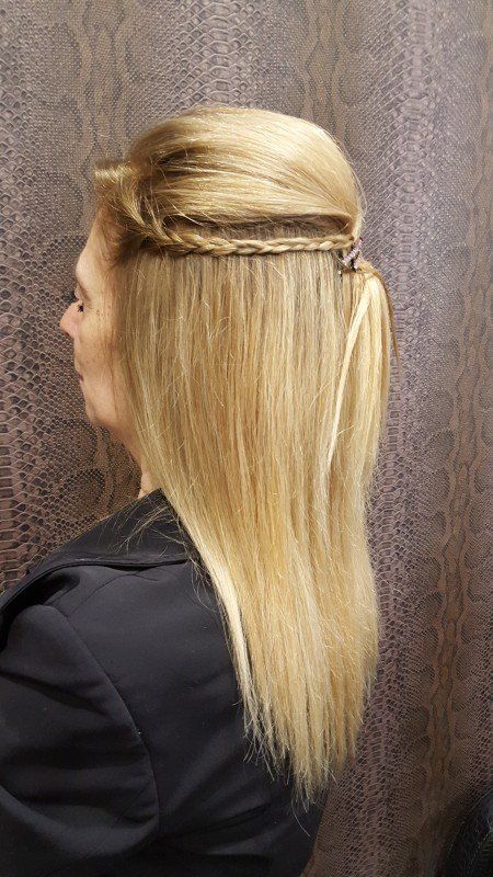 Una mujer con cabello largo y rubio lleva una cola de caballo trenzada.