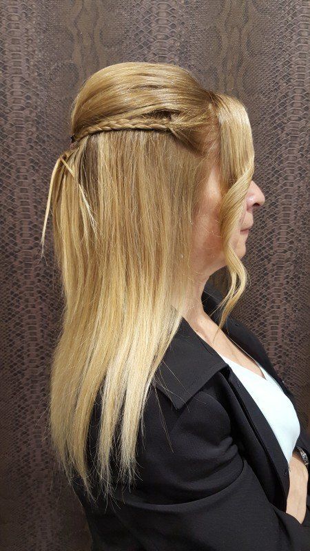 Una mujer con cabello rubio lleva una chaqueta negra y una camisa blanca.