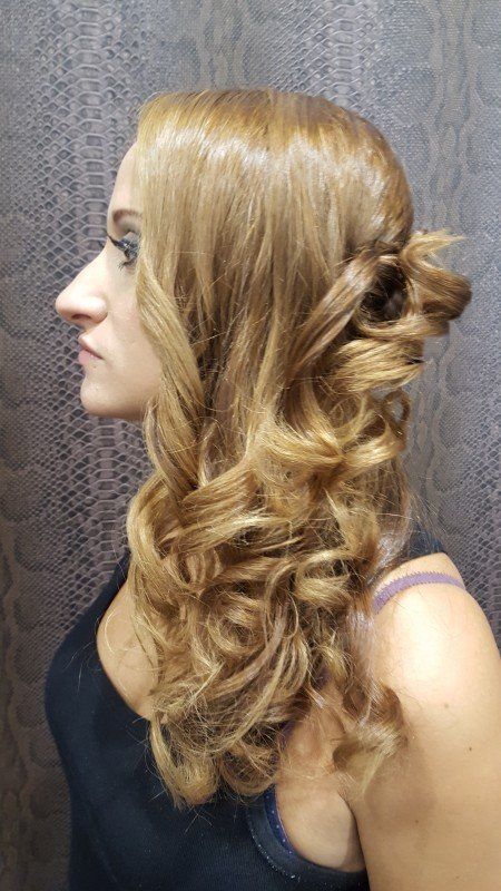 Una mujer con cabello largo y rubio lleva una camiseta negra sin mangas.