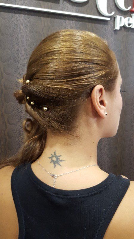 Una mujer con un tatuaje en la espalda lleva una camiseta negra sin mangas.