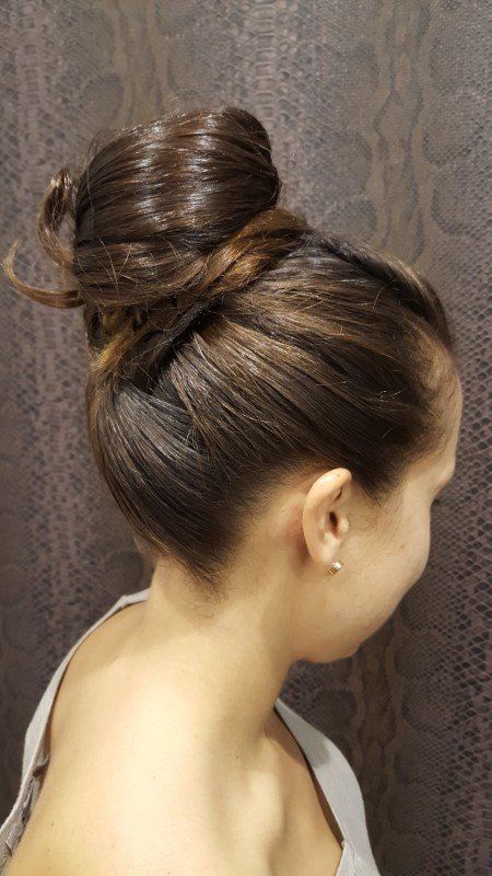 Una mujer lleva el pelo recogido en un moño.