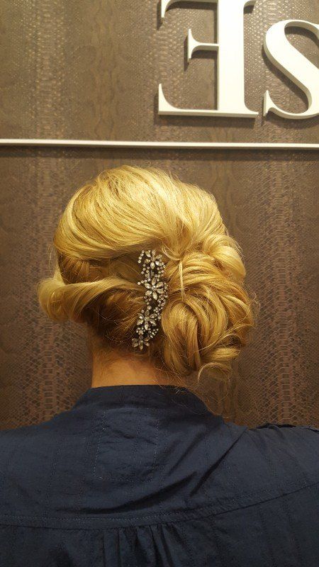 Una mujer lleva un moño con un peine en el pelo.