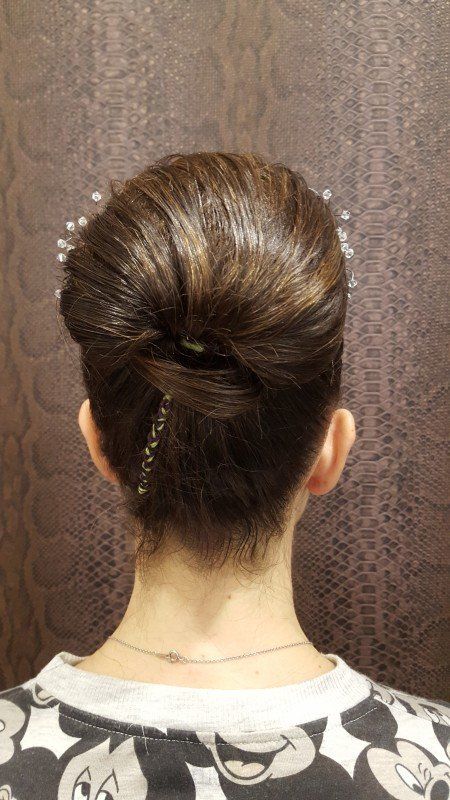 La espalda de una mujer que lleva una camiseta de Mickey Mouse y un moño.