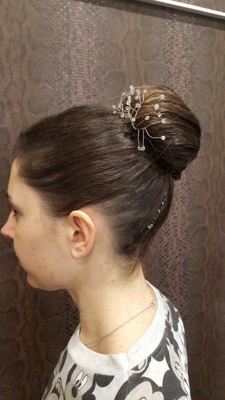 Una mujer lleva el pelo recogido en un moño con una horquilla.