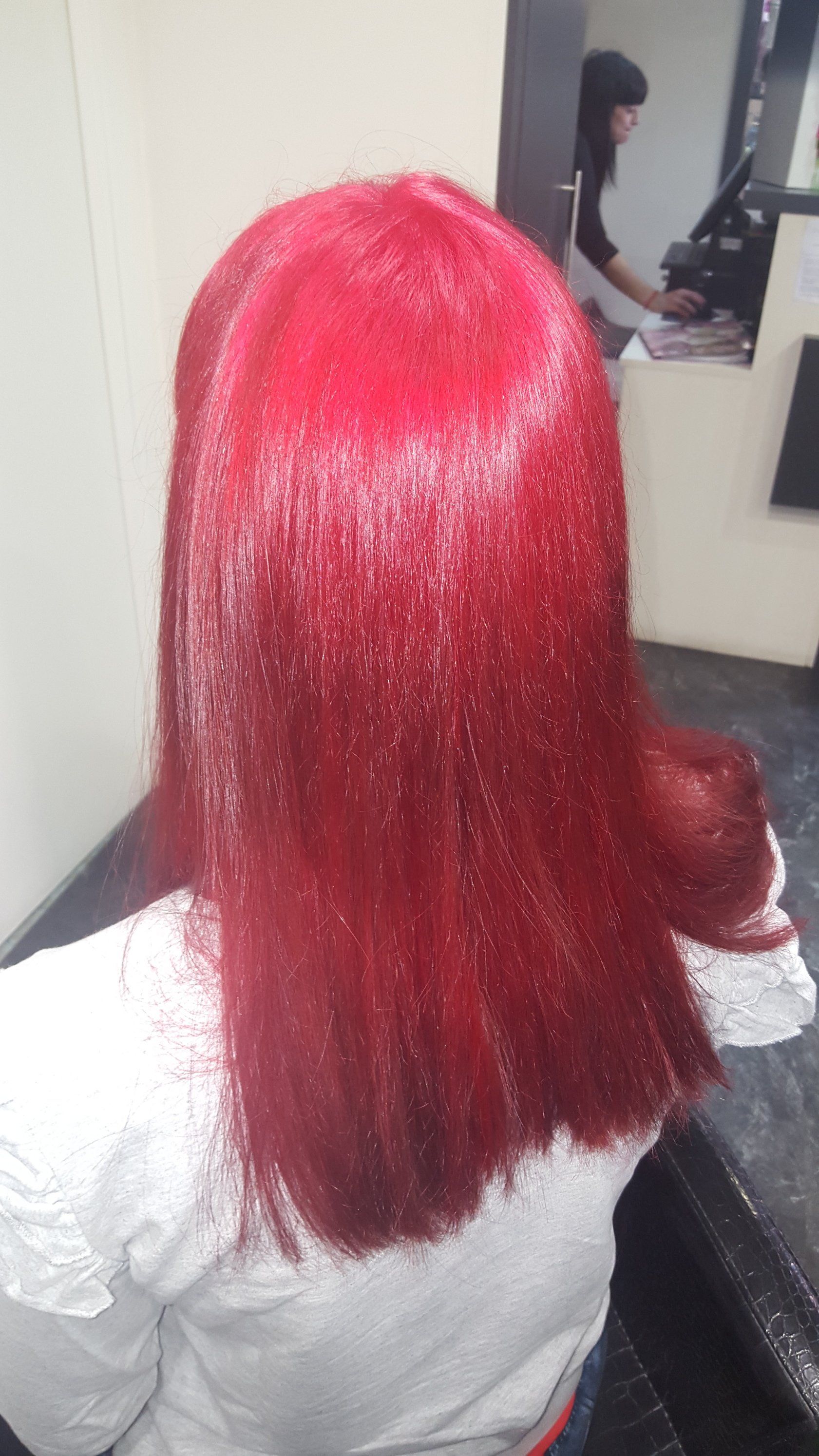 Una mujer con cabello rojo está sentada frente a un espejo.