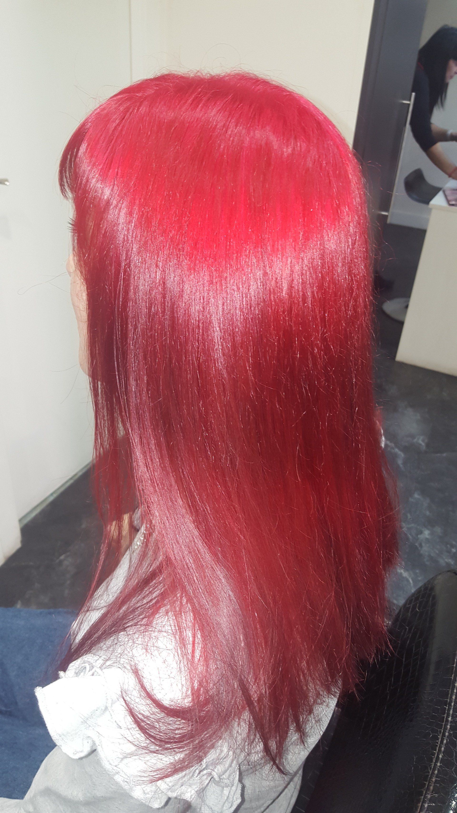 Una mujer con cabello rojo está sentada en una silla.