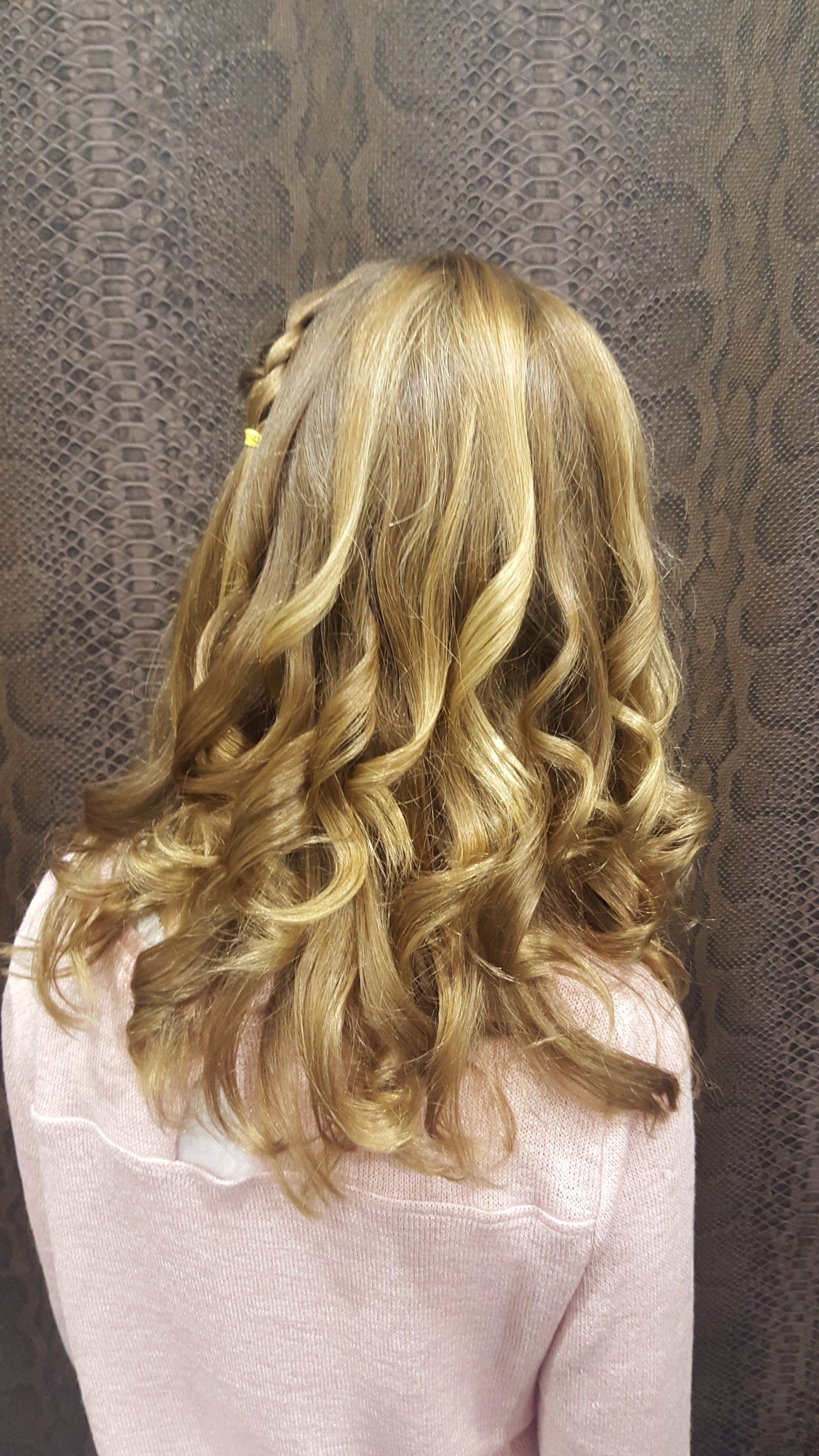 Una mujer con cabello largo y rubio lleva un suéter rosa.