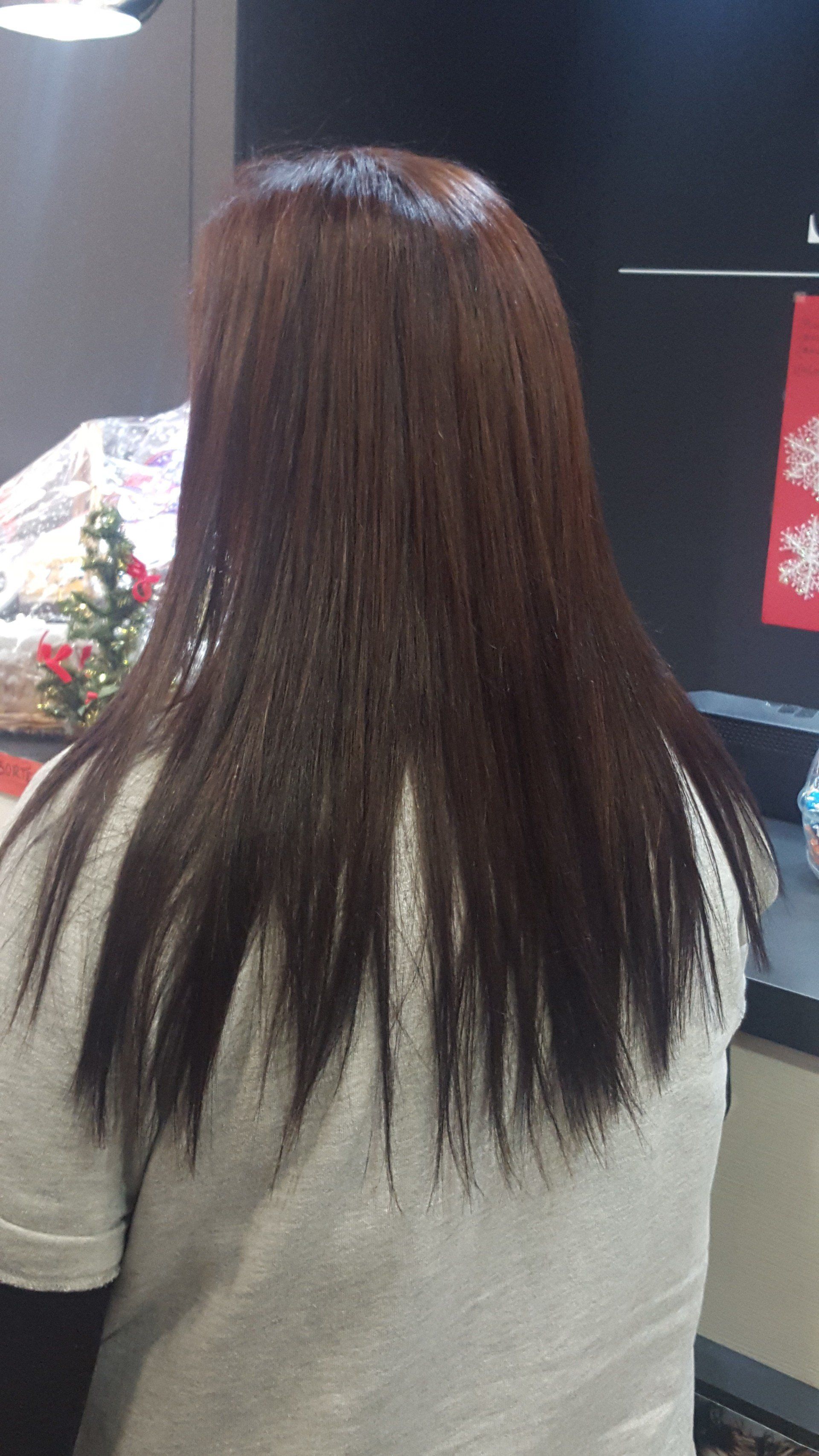 Una mujer con cabello largo y castaño está sentada frente a un televisor.