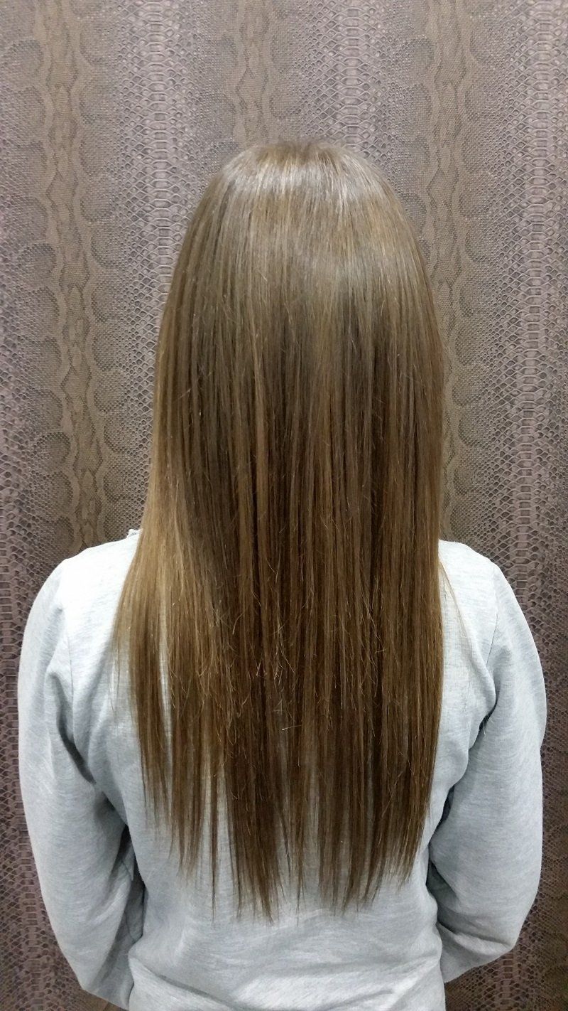 Una mujer con cabello largo está parada frente a una pared.