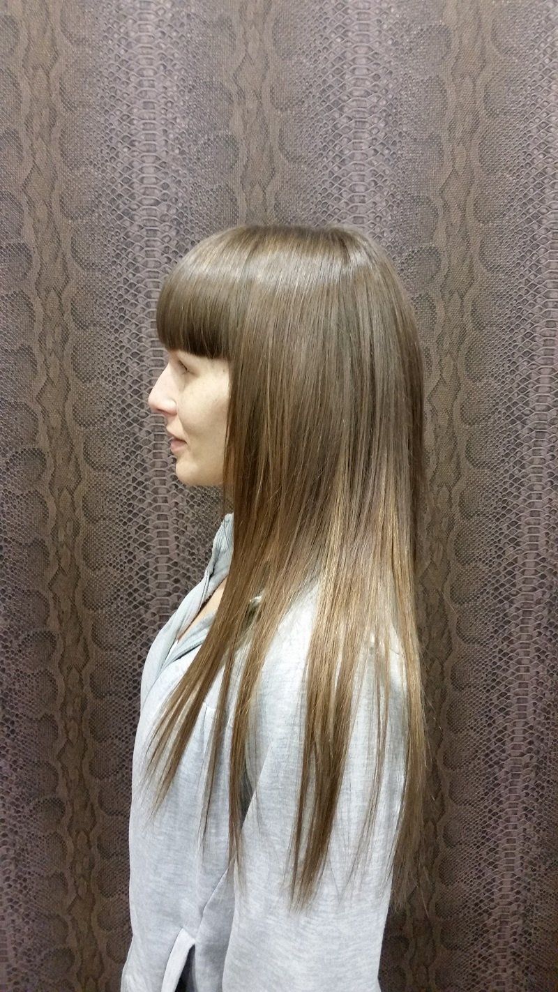 Una mujer con cabello largo está parada frente a una pared.