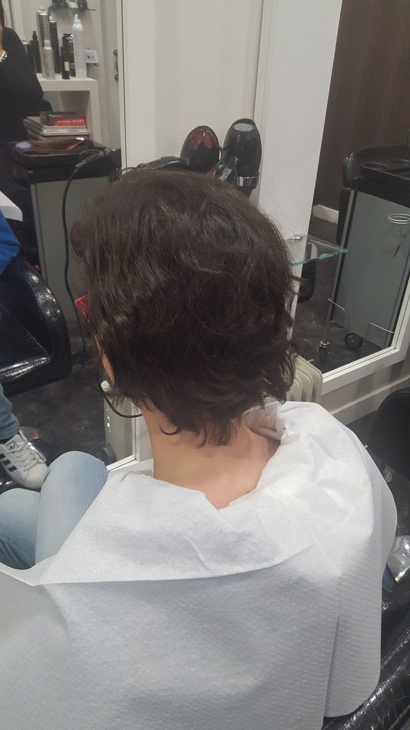 Una mujer está sentada en una silla en una peluquería.